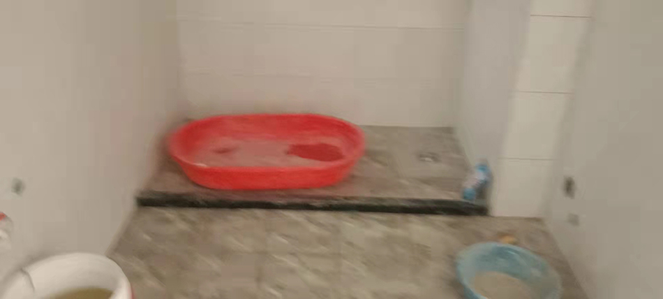 紅色水盆此前用來鋪瓷磚，何明中洗幹淨後用來洗澡。