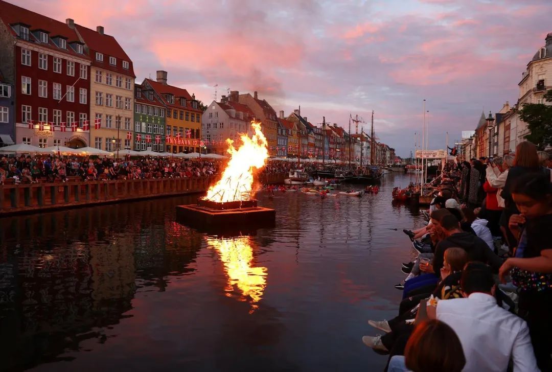 ▲當地時間2021年6月23日晚，人們在丹麥哥本哈根新港觀看慶祝仲夏節的篝火晚會。圖/新華社